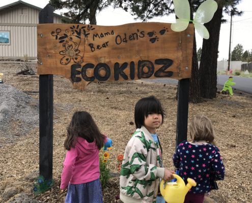 Watering Flowers At The Sign Mama Bear Odens Preschool In Bend Sign